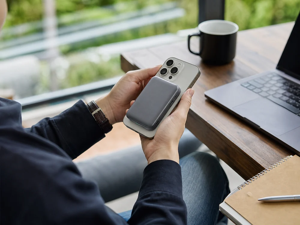 デスクでiPhone背面に装着して使うグレーのMagSafe対応モバイルバッテリー