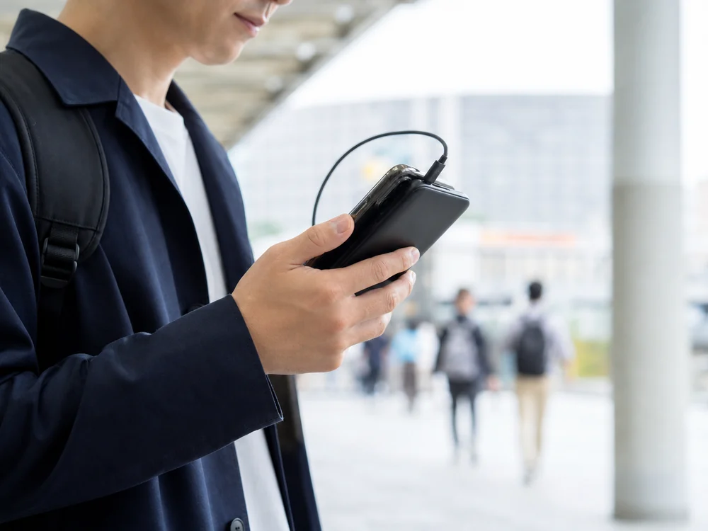 スマートフォンと重ねて持ちやすい薄型モバイルバッテリーの使用イメージ