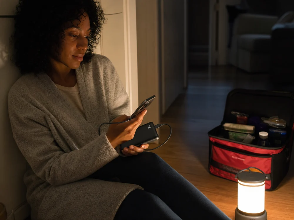UGREENの薄型モバイルバッテリーで夜にスマホを充電しているイメージ