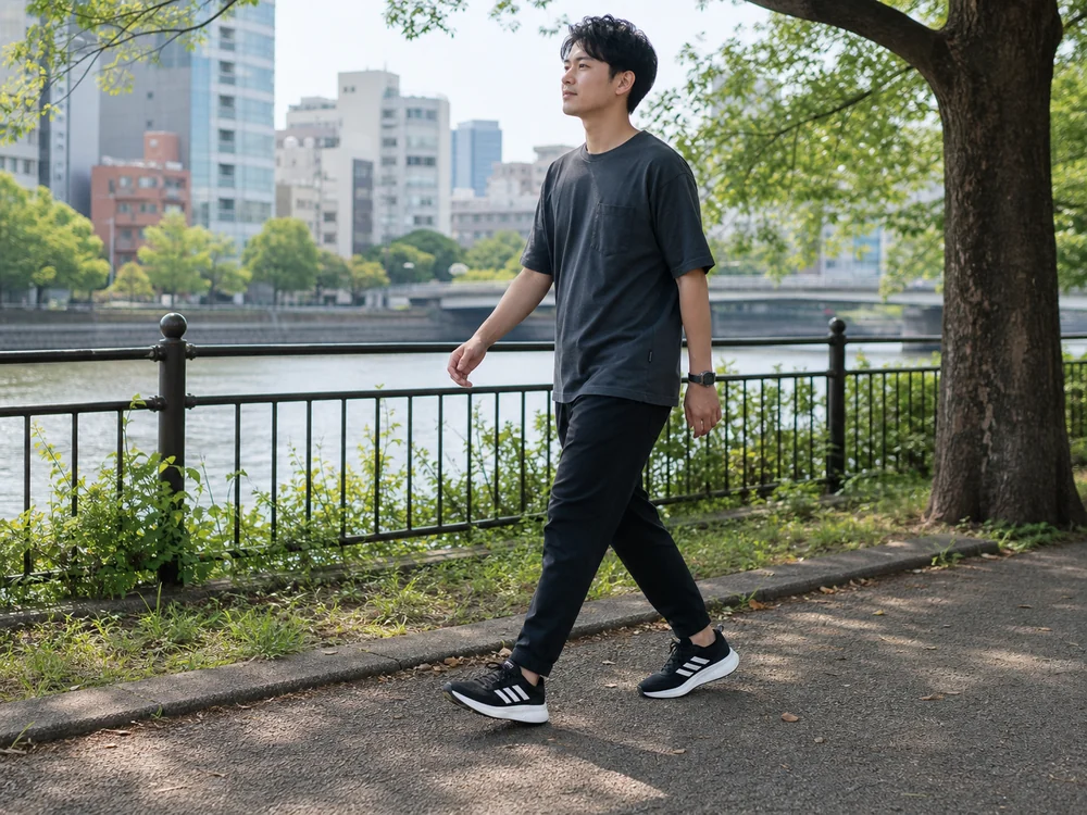 黒白のギャラクシー6を履いて歩道を歩く男性の足元