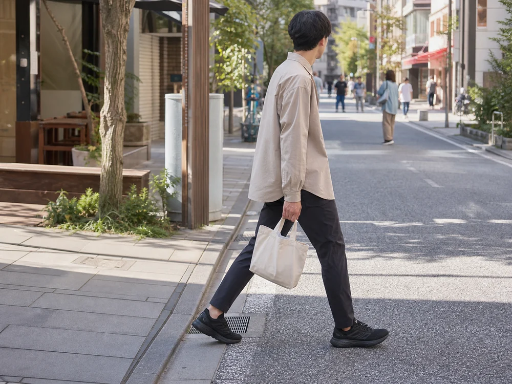 シンプルな私服に黒いコアランナーを合わせて街を歩く様子