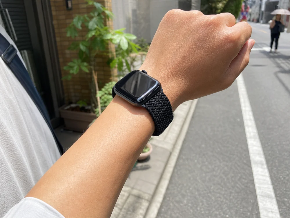 ブラックの編み込みナイロンバンドを付けたApple Watchを夏の外出中に使っている手元