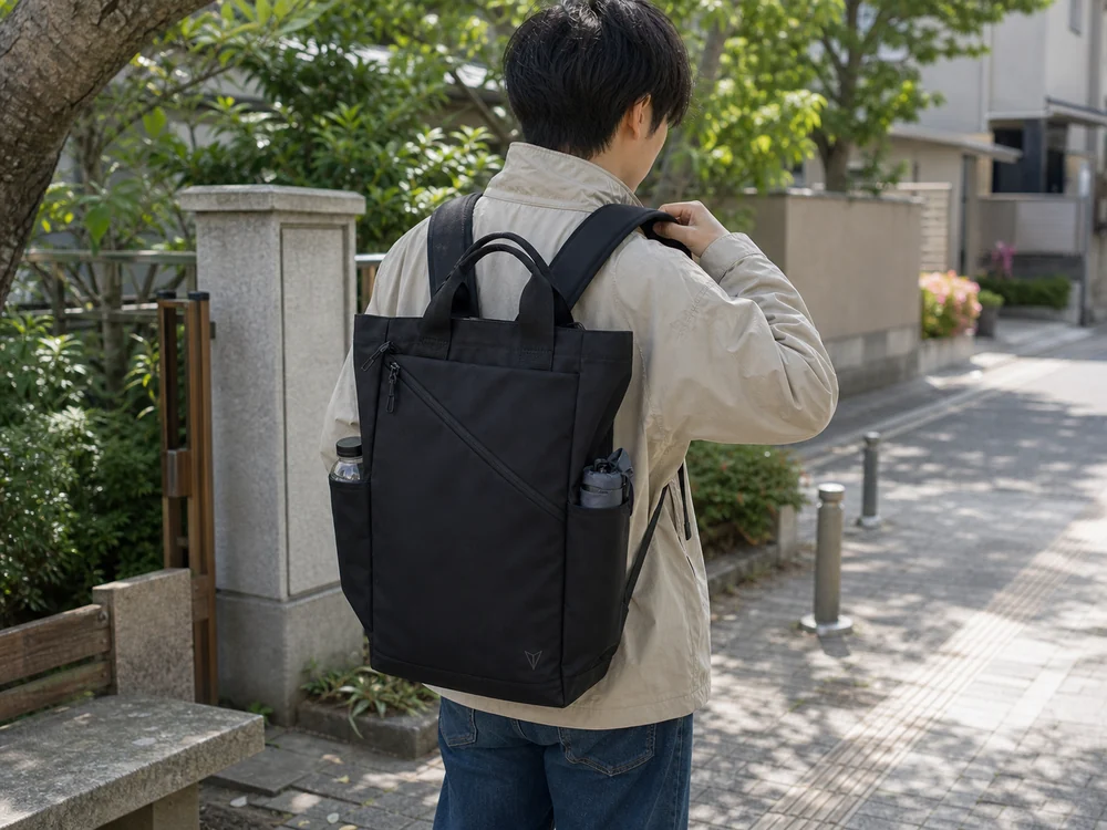 黒いトートリュックに外出用品を入れて持ち方を切り替える街歩き前のシーン
