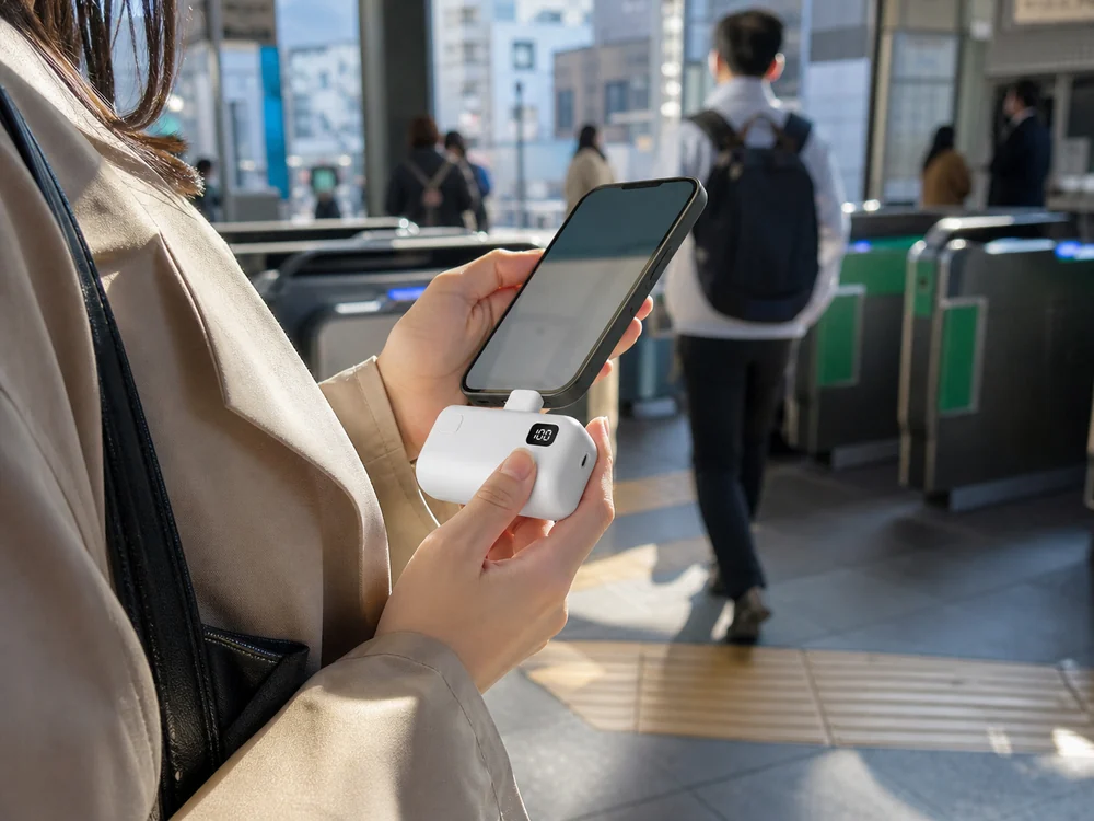 通勤中にスマホへ直挿しして使う白い小型モバイルバッテリー