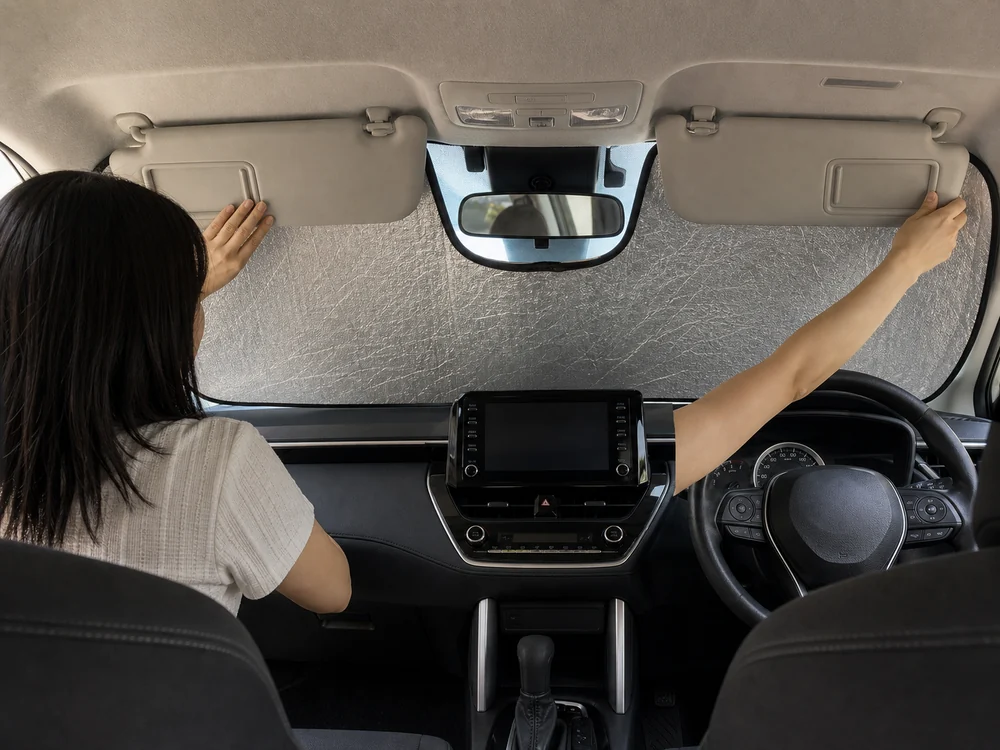 カローラクロスの車内でサンバイザーを使ってサンシェードを固定する様子