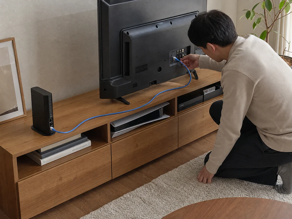 テレビ台でルーターからテレビへ青い2mのLANケーブルを配線する様子