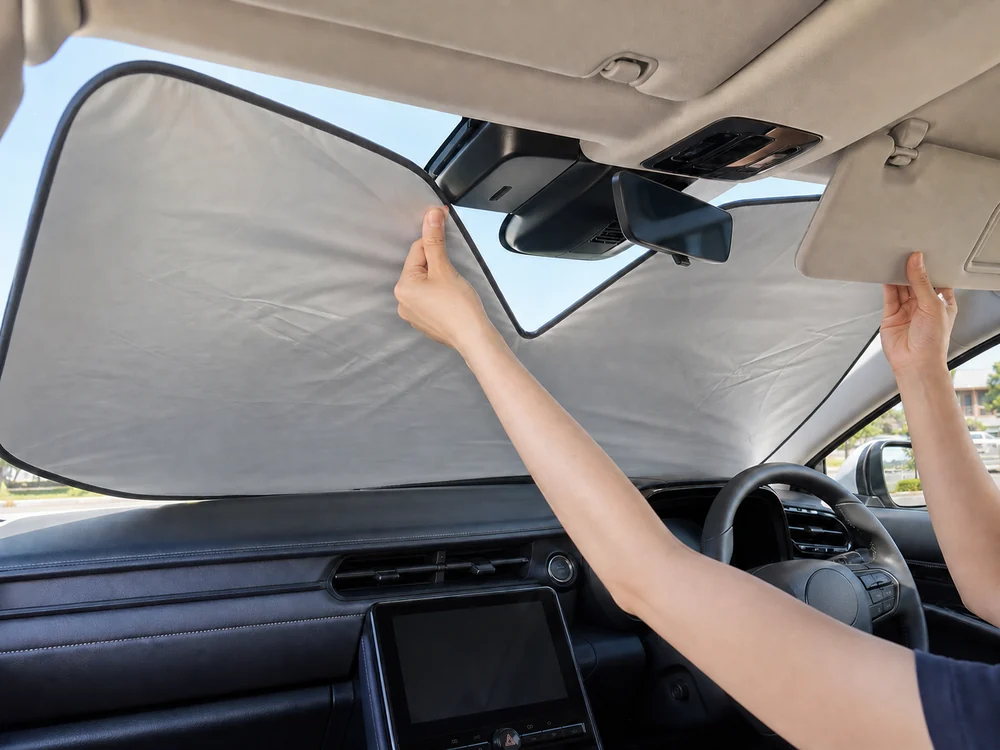 車内でミラー周辺を避けながらサンバイザーでサンシェードを固定する様子