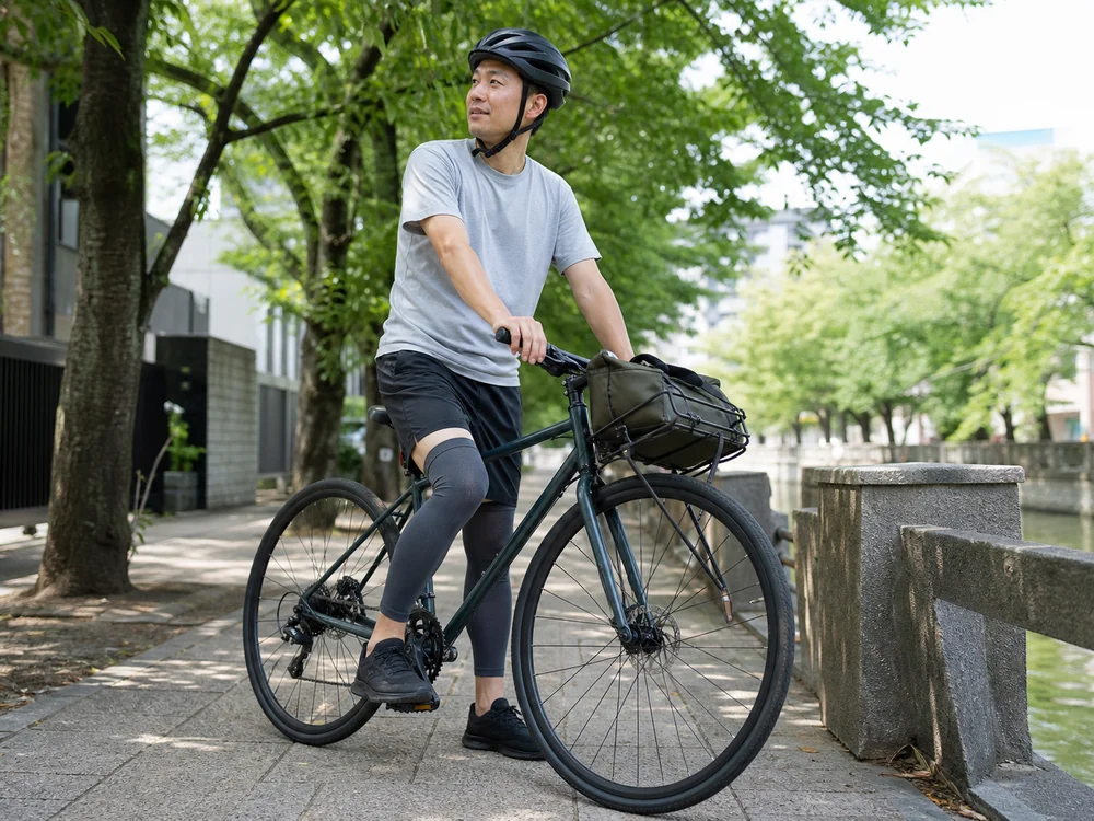 夏の自転車移動でダークグレーのレッグカバーを着けた人