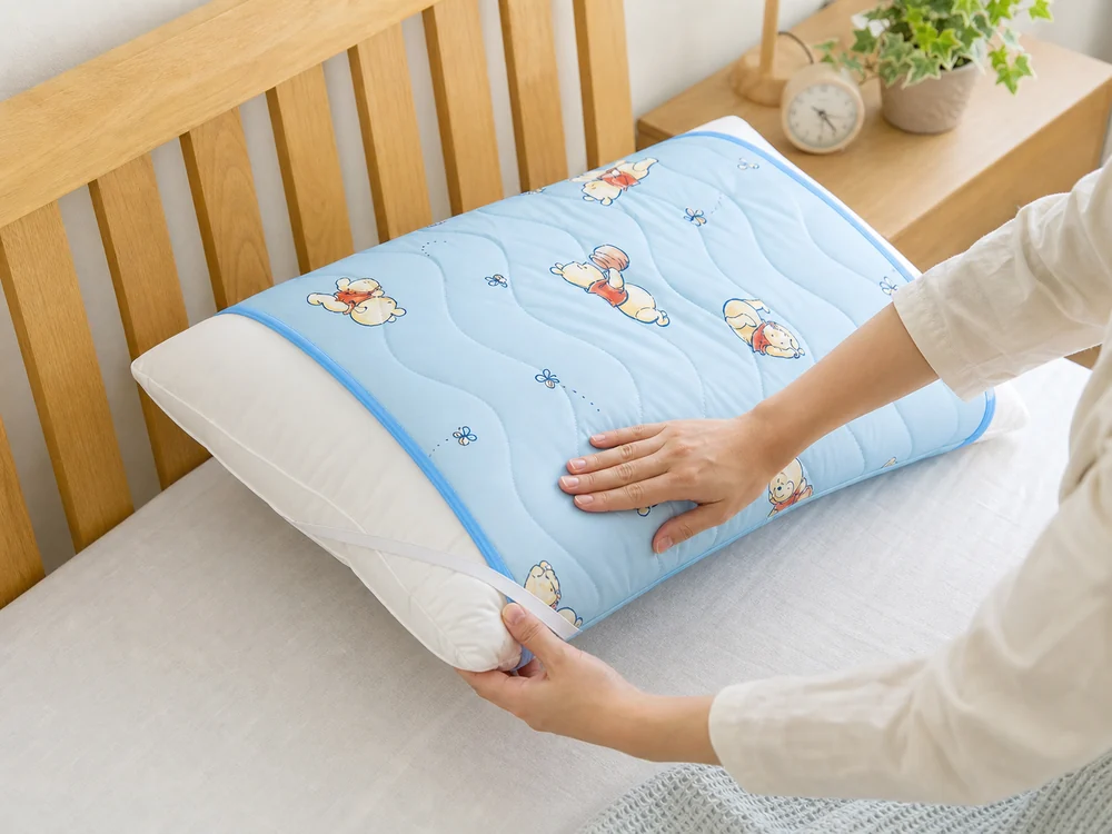 水色の冷感枕パッドのゴムを白い枕に掛けて取り付ける様子