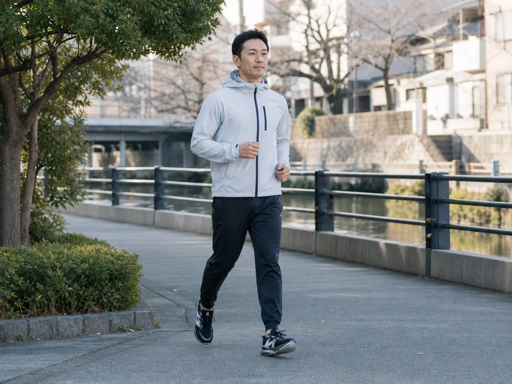 朝の住宅街を黒とシルバーのランニングシューズで軽く走る人