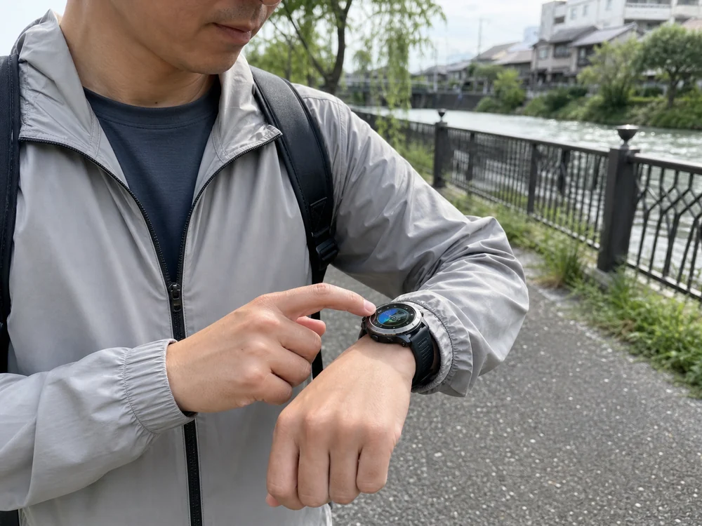 散歩中に丸型スマートウォッチの画面をスワイプする様子