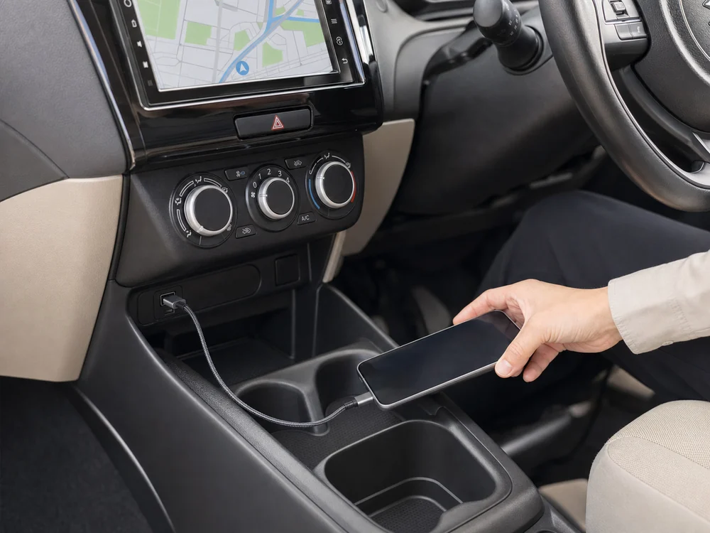 車内のUSB-Aポートとスマートフォンをグレーの編み込みケーブルで接続する様子