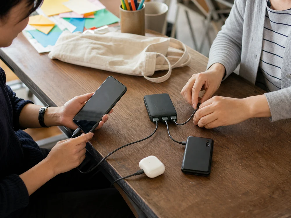 地域ワークショップの休憩中に3本のケーブルをモバイルバッテリーへつなぐ様子