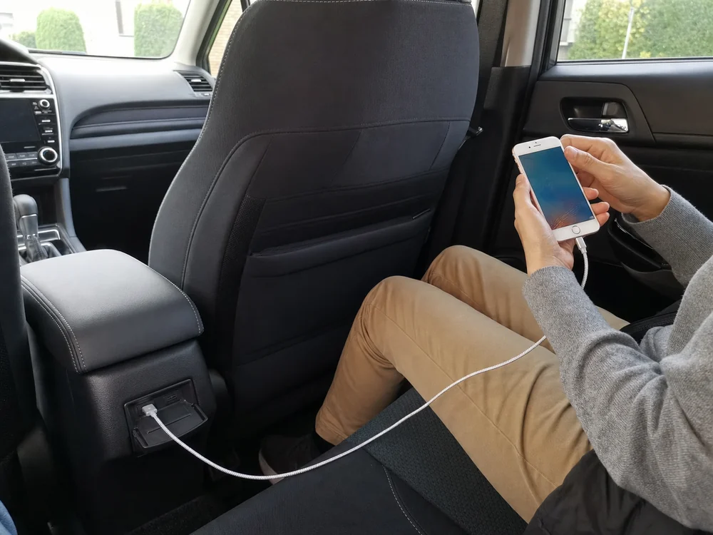 車内のUSB-Aポートから後席まで2mのライトニングケーブルを伸ばす様子