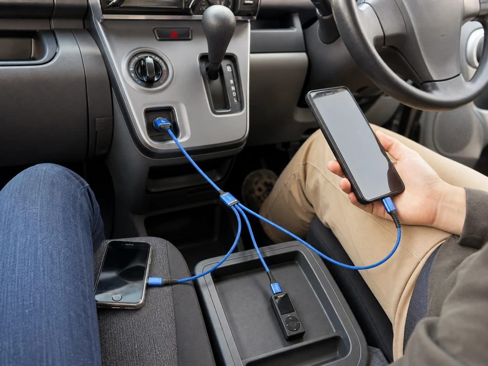 車内のUSB-Aポートから3台へ分岐する青い充電ケーブル